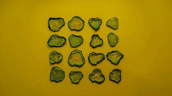 Kurutulmuş salatalıklar, sarı arka planda halkalara bölünmüş.