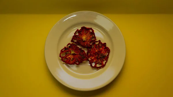 Tres Piezas Secas Tomate Sobre Plato Blanco Sobre Fondo Amarillo — Foto de Stock