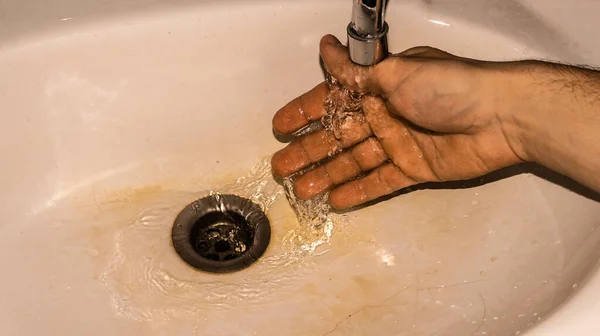 流れる水の下の男の手 — ストック写真