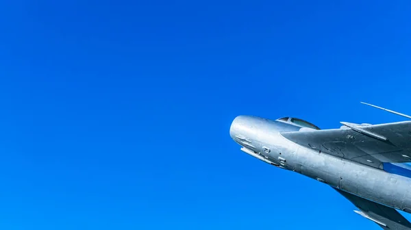 Eski bir askeri uçak, gökyüzünde uçan bir avcı uçağı.