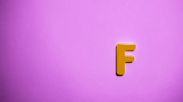 Pembe arkaplandaki anguilla alfabesinin harfi