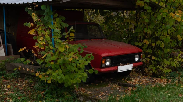 Kırsal kesimde eski bir garajda eski kırmızı bir araba.