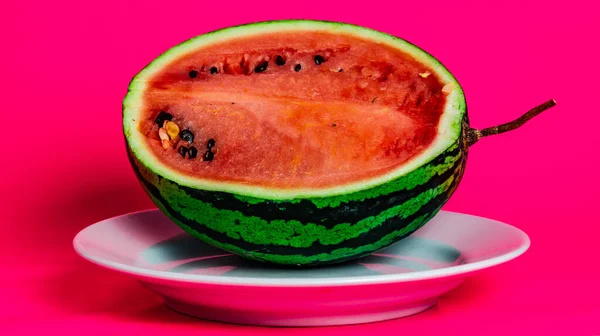 Pembe arka planda bir tabakta karpuz