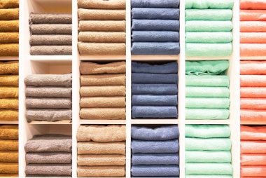 Satış mağazasındaki raflarda birçok renkli havlu katlanıyor. . 