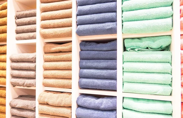 Satış mağazasındaki raflarda birçok renkli havlu katlanıyor. . 
