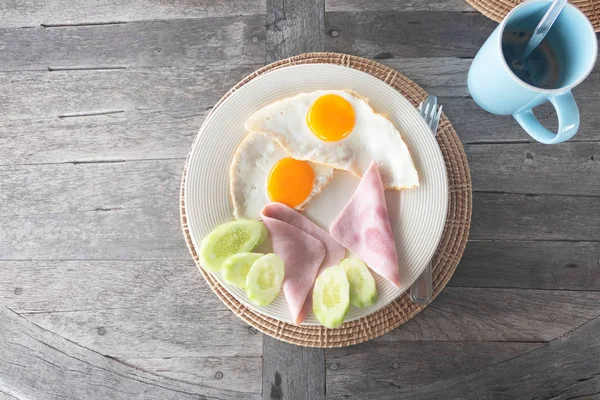 Frühstücksei Mit Schinken Auf Weißem Teller Und Kaffee Auf Holztisch — Stockfoto