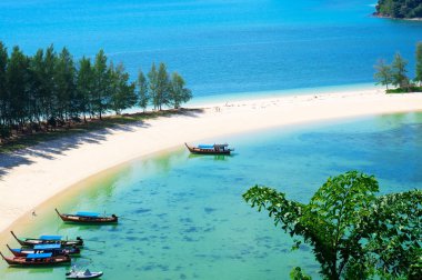 güzel sahne ile ahşap tekne mavi deniz ve mavi gökyüzü tropik Sahilde plaj beyaz kum üzerinde.