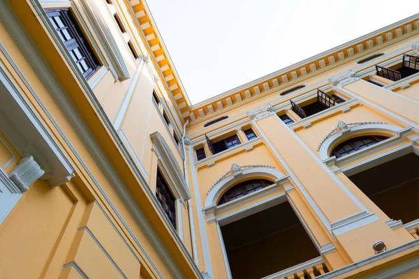 the beautiful yellow building ,Vintage building and many black window .