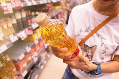 Woman choosing product in a supermarket .woman shopping in supermarket and reading product information.