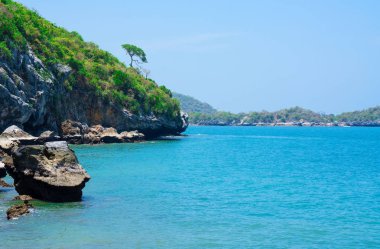 Yaz aylarında deniz kenarında, taş sahil kıyısında dalgalar . mavi deniz mavi gökyüzü arka plan. Seyahat, Tatil ve Tatil konsepti. Tropikal plaj .