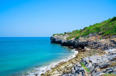Yaz aylarında deniz kenarında, taş sahil kıyısında dalgalar . mavi deniz mavi gökyüzü arka plan. Seyahat, Tatil ve Tatil konsepti. Tropikal plaj .