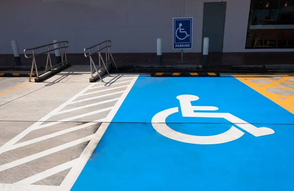 traffic sign about handicapped symbol painted in bright blue . Disabled parking spaces .