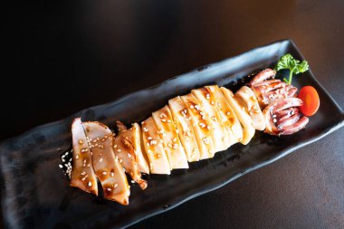 Siyah tabakta teriyaki soslu ızgara kalamar. Japon deniz ürünleri.