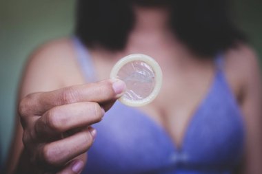 Yatak, bir prezervatif gösterilen kadın prezervatifi ön planda odaklanın