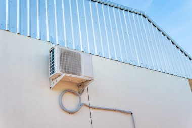 Klima kompresör ünitesi beyaz duvar, açık.