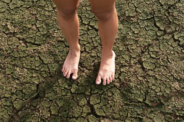 Çıplak ayaklı kadın kuraklık arazi üzerinde ayakta