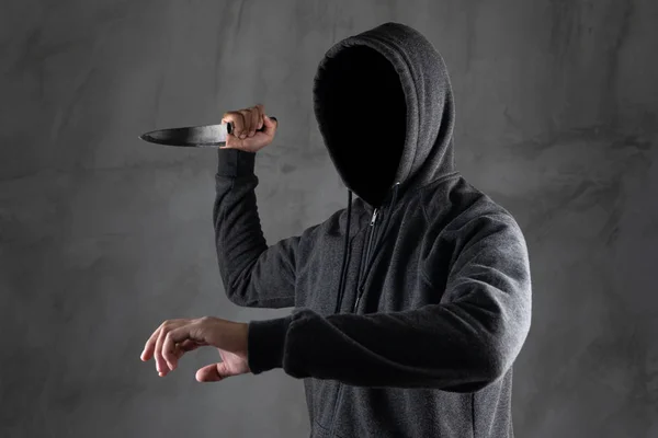 危险的戴头罩的人站在黑暗中，拿着一把刀法 — 图库照片