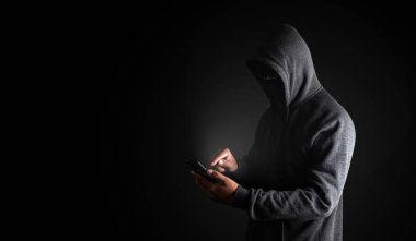 Akıllı Telefon Kullanan Hacker. Gizli yüzü l ile siyah elbiseli erkekler