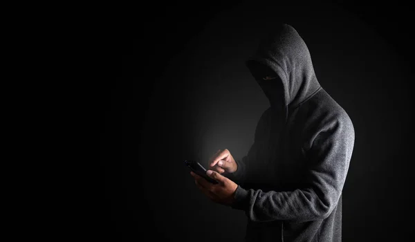 Hacker Usando Smartphone. Hombres en ropa negra con cara oculta l — Foto de Stock