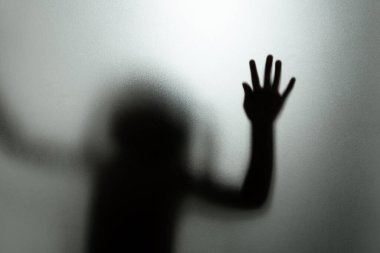 Mat camın arkasında bir çocuğun hayalet konsepti bulanık el ve vücut odaklanması