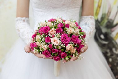 Gelinin elinde bir buket çiçek.