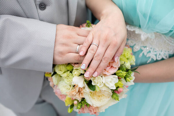 Bride and groom hands with wedding rings