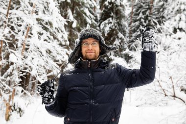 Kulağı olan kürk kış şapkalı adam gülümseyen portre flep. Ormanın içinde aşırı