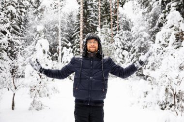 Kulağı olan kürk kış şapkalı adam gülümseyen portre flep. Ormanın içinde aşırı