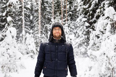 Kulağı olan kürk kış şapkalı adam gülümseyen portre flep. Ormanın içinde aşırı