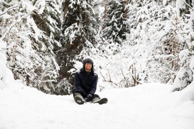Kulağı olan kürk kış şapkalı adam gülümseyen portre flep. Ormanın içinde aşırı