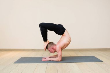 Pratik yoga yoga sınıfına sportif adam. Akrep poz