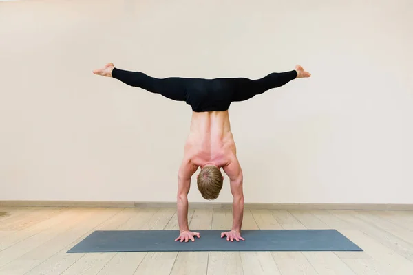 Sporty man practicing yoga on yoga class