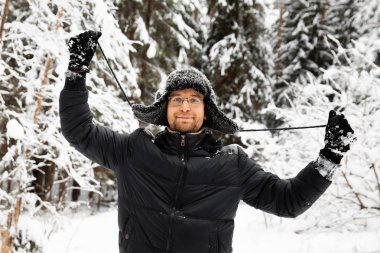 Kulağı olan kürk kış şapkalı adam gülümseyen portre flep. Ormanın içinde aşırı