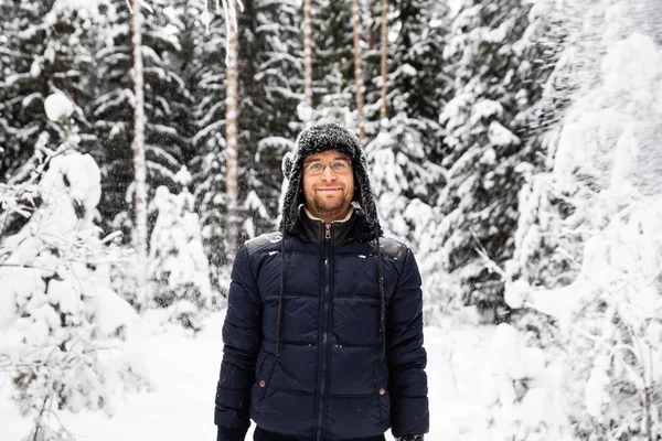 Человек Меховой Зимней Шляпе Ушными Закрылками Улыбается Портрет Лесу — стоковое фото