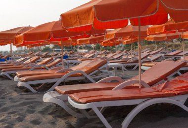 plaj sandalyeleri, günbatımı kum plaj üzerinde kırmızı şemsiye ile