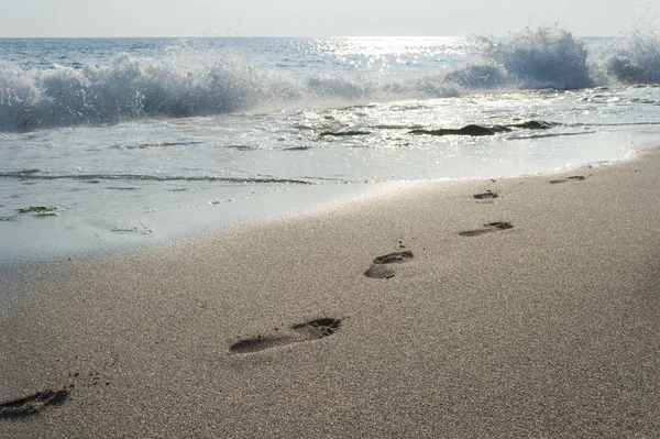 砂の上の足跡のサーフィン 波の海岸 — ストック写真