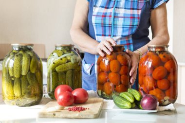 mutfakta masada tablonun yanındaki mavi ekose tunik kadında kavanoz turşu, salamura domates ve salatalık, gıda, masaya vardır taze domates, salatalık, soğan, sarımsak, sebze, 