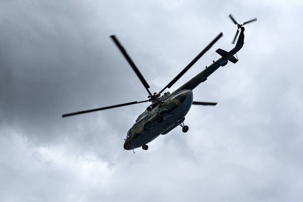 helicopter flyin in the sky against a background of clouds, screws, paddles, air transport, flight