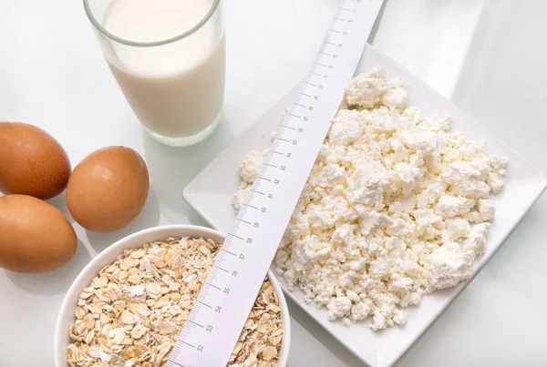 protein food, protein diet, measuring tape, glass of milk, cottage cheese, eggs, oatmeal,