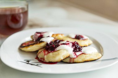 bir plaka üzerinde İsveç kirazı krema soslu krep Servis Kahvaltı börek ile