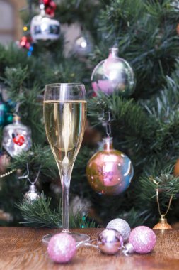 1 bardak köpüklü şarap, pembe Noel topları arka planda Noel ağacı, alkollü içki, şampanya