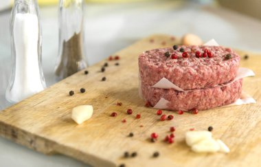 2 ham domuz biftek ahşap bir gemide baharat tuz, sarımsak, biber, tuz shaker, biber Çalkalayıcı, et, beşamel sos ile