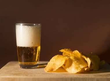 köpük, karanlık bir arka plan, alkollü içki ahşap bir gemide üzerindeki fişlere light bira bardak