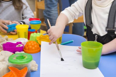 Childs'ın bir fırça ile çocuk berabere bir boş kağıda çizim el
