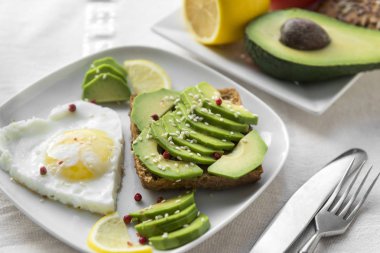 Avokado dilimleri, plaka, limon, çatal, gıda pişmiş yumurta ile sandviç,