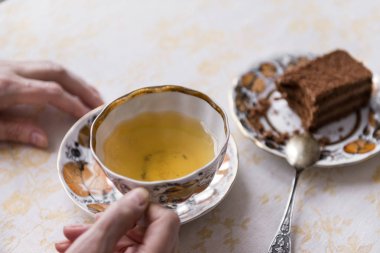 Yeşil çay elinde, bir parça çikolatalı kek