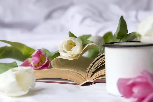 pembe ve beyaz güller, açık bir kitap, kupa