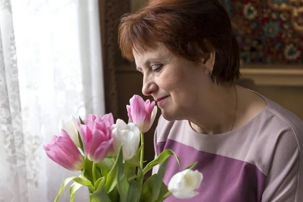 1 adult woman with a bouquet of tulips, pink and white tulips, flowers
