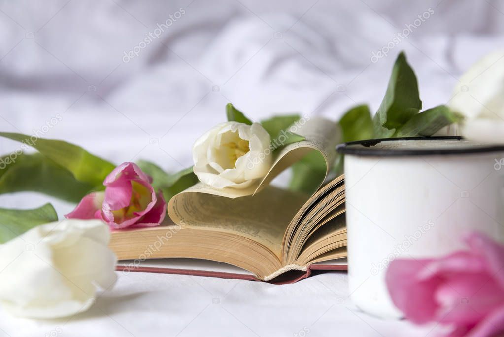 pink and white roses, an open book, mug