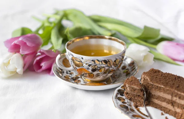 chocolate cake, mug of tea,  tulips